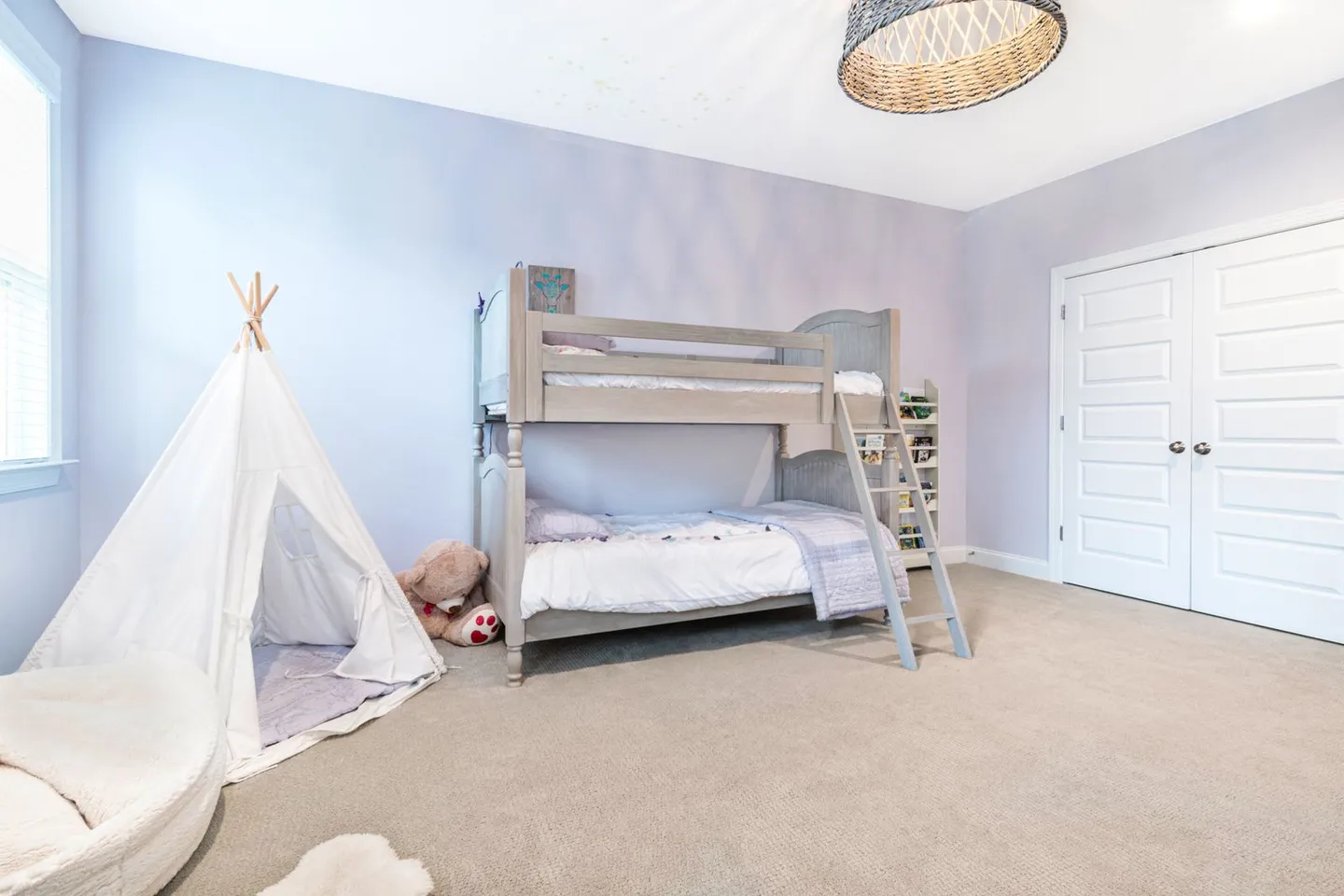 White play tent and floor cushions beside a wooden bunk bed.