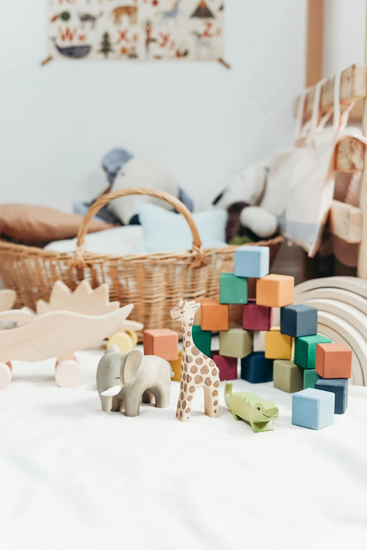 Wooden animal toys and colorful blocks beside a woven basket.